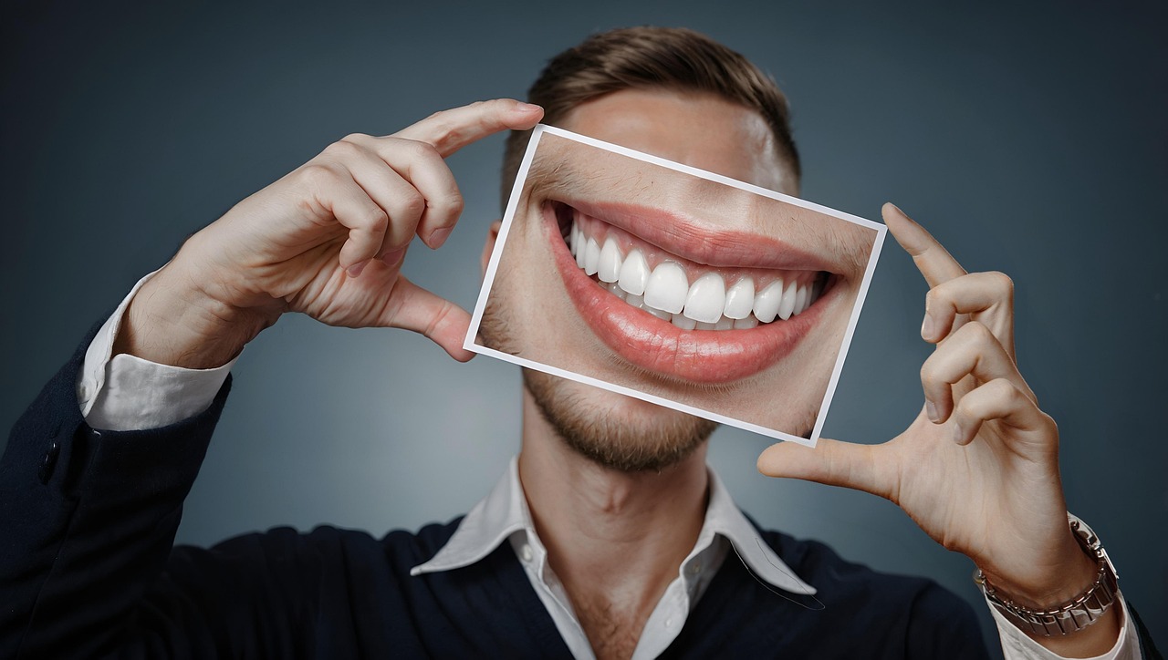 Man houdt een foto van een glimlach voor zijn gezicht in een professionele setting.